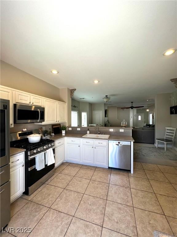 8340 Winterchase Pl, Las Vegas, NV 89143 - kitchen featuring appliances with stainless steel finishes, a sink, a peninsula, open floor plan, and light tile patterned floors