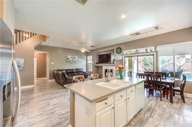 5862 Bluthe Bridge Ave, Las Vegas, NV 89141 - kitchen with a sink, dishwasher, light countertops, freestanding refrigerator, and baseboards