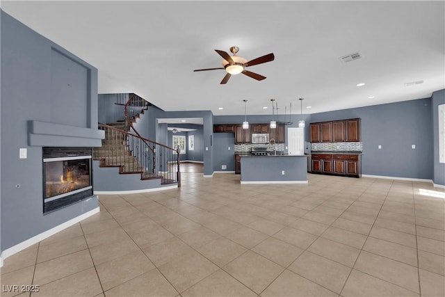 4063 Lower Saxon Ave, North Las Vegas, NV 89085 - unfurnished living room with a ceiling fan, stairs, a glass covered fireplace, light tile patterned floors, and recessed lighting