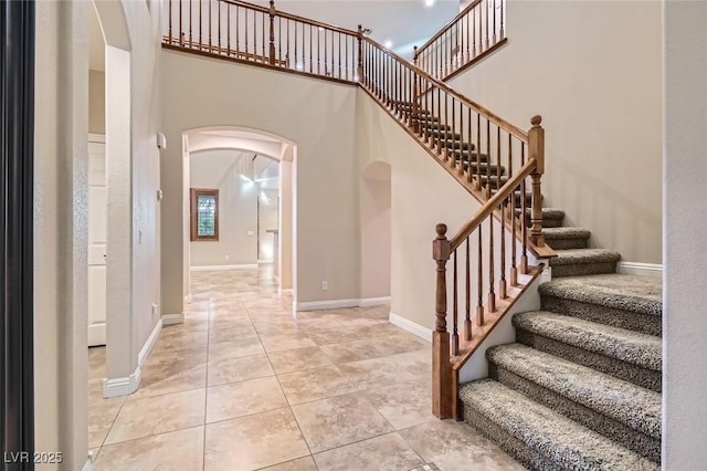 368 Misty Moonlight St, Henderson, NV 89015 - entrance foyer featuring arched walkways, light tile patterned floors, a towering ceiling, stairs, and baseboards