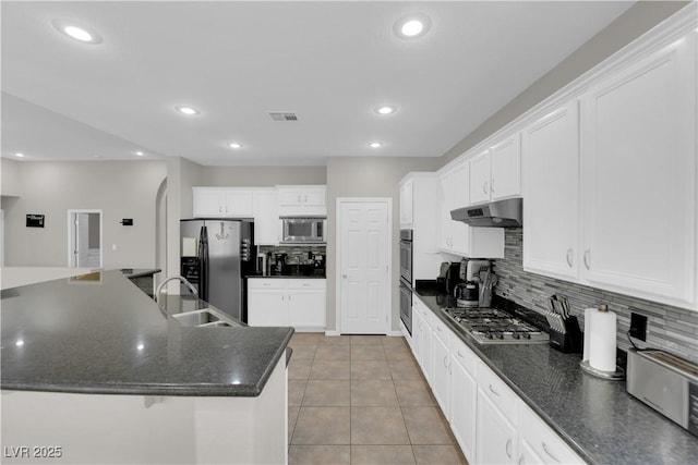11244 Gammila Dr, Las Vegas, NV 89141 - kitchen with stainless steel appliances, a sink, under cabinet range hood, backsplash, and light tile patterned floors
