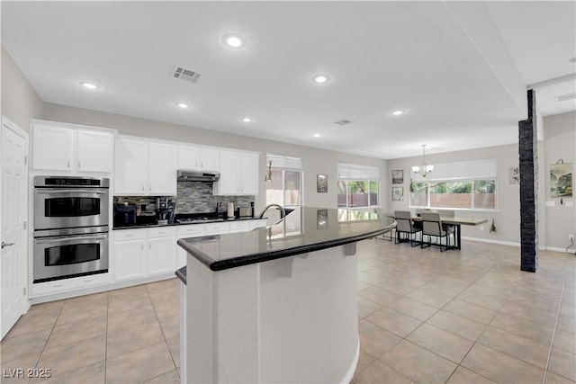11244 Gammila Dr, Las Vegas, NV 89141 - kitchen featuring stainless steel double oven, under cabinet range hood, dark countertops, a chandelier, and recessed lighting