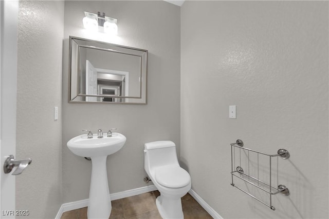 11244 Gammila Dr, Las Vegas, NV 89141 - half bathroom featuring toilet, tile patterned floors, baseboards, and a sink