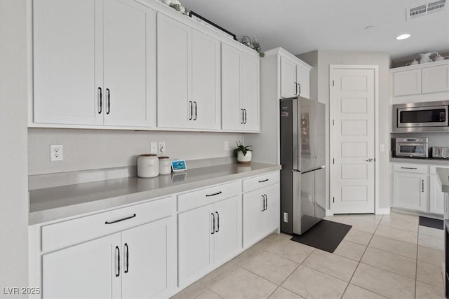 10324 Stroma Ave, Las Vegas, NV 89166 - kitchen featuring appliances with stainless steel finishes, white cabinetry, light tile patterned floors, light countertops, and recessed lighting