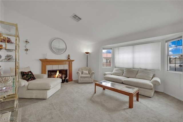 carpeted living room with plenty of natural light and a tiled fireplace