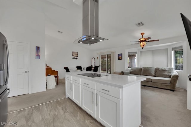 kitchen featuring light colored carpet, extractor fan, black electric cooktop, stainless steel fridge, and a ceiling fan