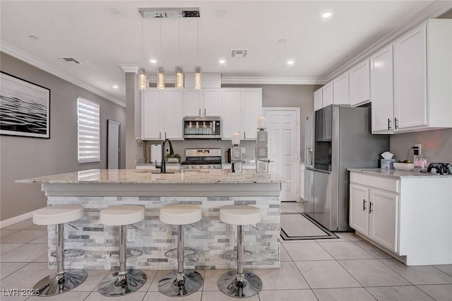 1637 Harvest Pecan Ct, Las Vegas, NV 89108 - kitchen featuring stainless steel appliances, crown molding, white cabinets, a kitchen breakfast bar, and recessed lighting