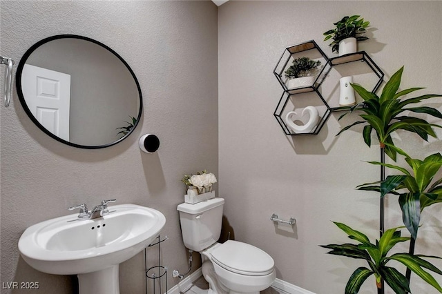 1637 Harvest Pecan Ct, Las Vegas, NV 89108 - half bathroom with toilet, baseboards, and a sink