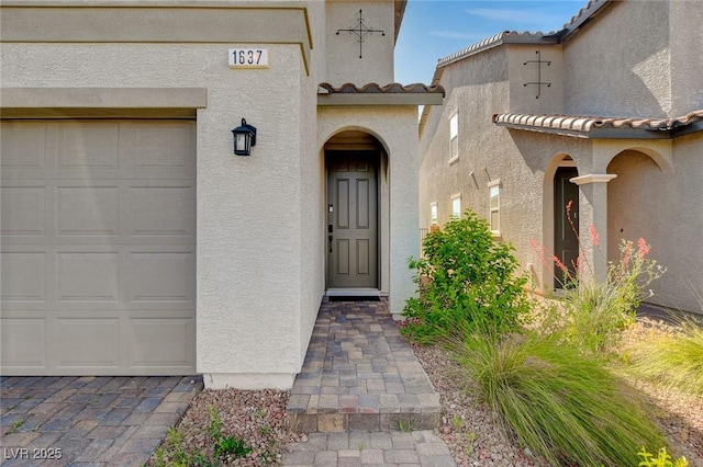 1637 Harvest Pecan Ct, Las Vegas, NV 89108 - view of exterior entry with a tiled roof, stucco siding, and a garage