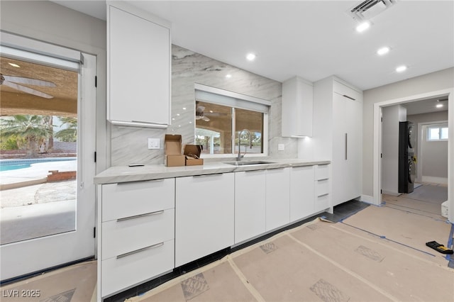 3075 Santa Margarita St, Las Vegas, NV 89146 - kitchen with a sink, white cabinetry, light countertops, modern cabinets, and tasteful backsplash