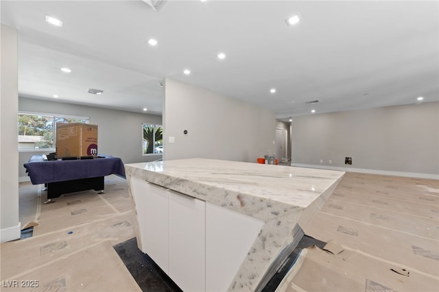 3075 Santa Margarita St, Las Vegas, NV 89146 - kitchen with white cabinets, open floor plan, recessed lighting, a center island, and light stone countertops