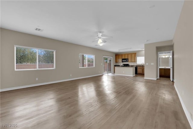 125 Sharp Edge Ave, North Las Vegas, NV 89031 - unfurnished living room featuring a ceiling fan, light wood-style floors, and baseboards