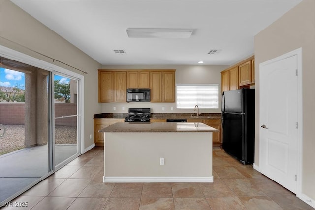 125 Sharp Edge Ave, North Las Vegas, NV 89031 - kitchen with black appliances, healthy amount of natural light, a kitchen island, light tile patterned floors, and recessed lighting