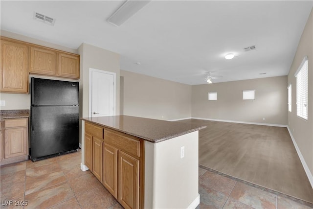125 Sharp Edge Ave, North Las Vegas, NV 89031 - kitchen with freestanding refrigerator, ceiling fan, a kitchen island, and baseboards