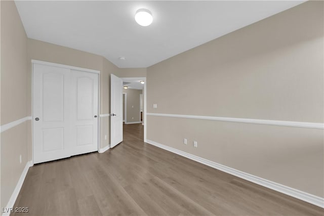 125 Sharp Edge Ave, North Las Vegas, NV 89031 - unfurnished bedroom featuring baseboards, wood finished floors, and a closet