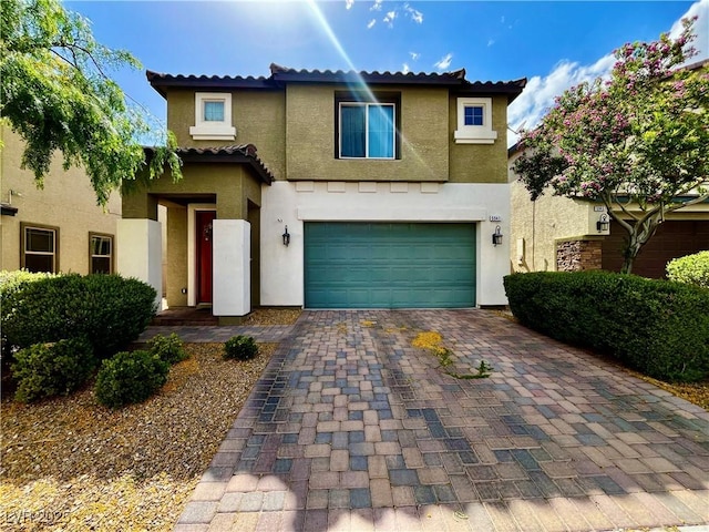 view of front facade with stucco siding, an attached garage, decorative driveway, and a tiled roof