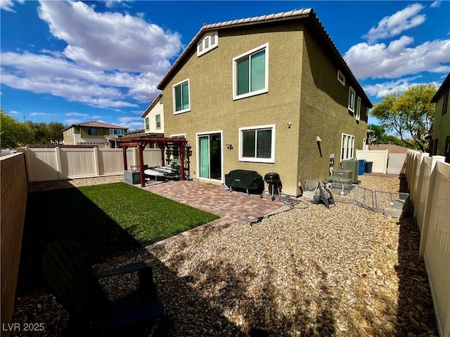 rear view of house featuring a pergola, stucco siding, a patio, and a fenced backyard