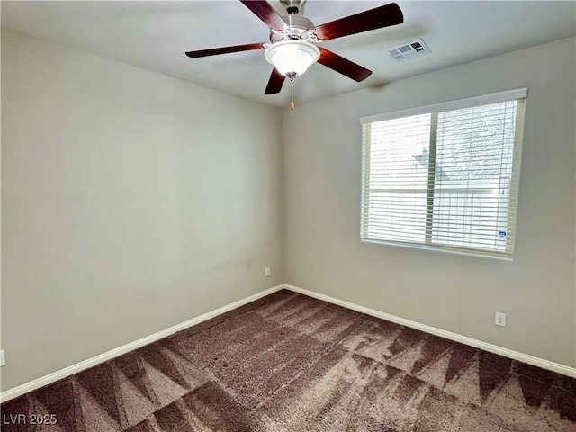 spare room with dark colored carpet, baseboards, and a ceiling fan