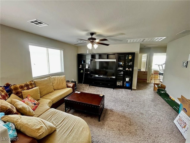 carpeted living room with healthy amount of natural light and ceiling fan