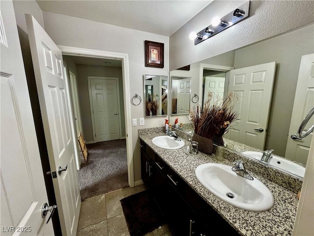 bathroom featuring double vanity, baseboards, and stone finish floors