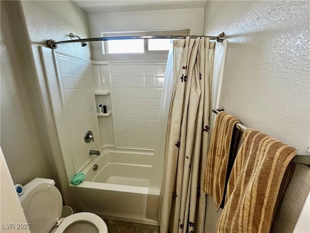 bathroom with toilet, shower / bath combo, and a textured wall