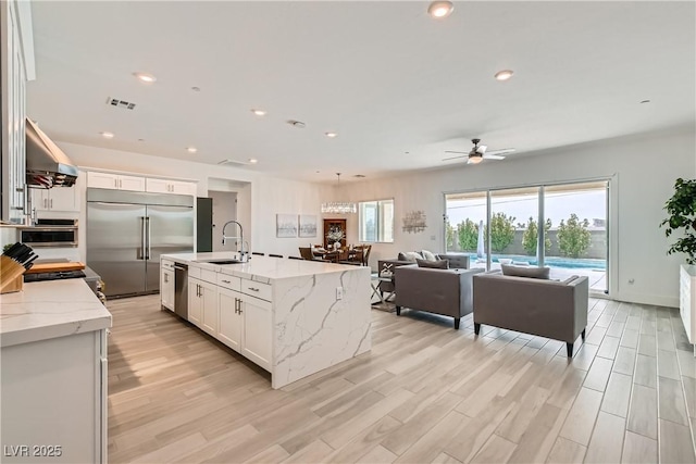 5321 Brayden Ct, Las Vegas, NV 89131 - kitchen featuring appliances with stainless steel finishes, ventilation hood, a sink, a ceiling fan, and white cabinets