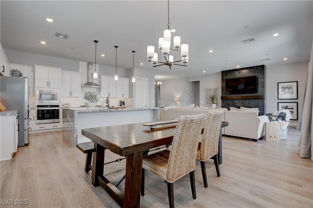 dining room with a chandelier, light wood finished floors, and recessed lighting