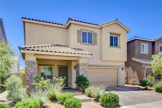 1055 Fish Pond Ave, Henderson, NV 89014 - view of front of home featuring a garage, stucco siding, a tile roof, decorative driveway, and stone siding