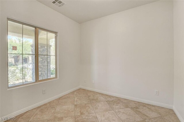 1055 Fish Pond Ave, Henderson, NV 89014 - spare room with healthy amount of natural light, light tile patterned floors, and baseboards