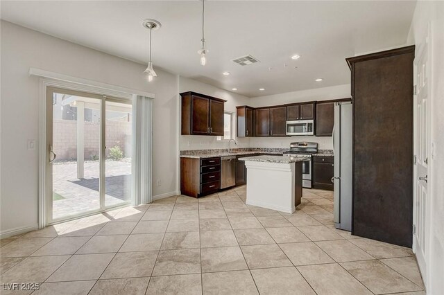 1055 Fish Pond Ave, Henderson, NV 89014 - kitchen with appliances with stainless steel finishes, dark brown cabinetry, light tile patterned floors, pendant lighting, and baseboards