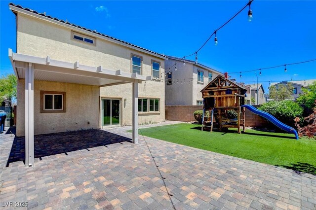 1055 Fish Pond Ave, Henderson, NV 89014 - back of property featuring stucco siding, a playground, and a patio area