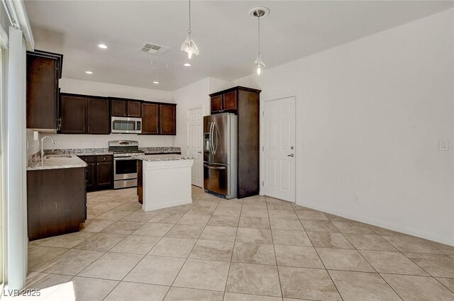 1055 Fish Pond Ave, Henderson, NV 89014 - kitchen with appliances with stainless steel finishes, a sink, dark brown cabinetry, light tile patterned floors, and a center island