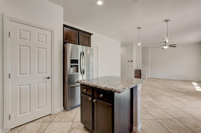 1055 Fish Pond Ave, Henderson, NV 89014 - kitchen featuring stainless steel fridge, light tile patterned flooring, dark brown cabinets, light stone countertops, and pendant lighting