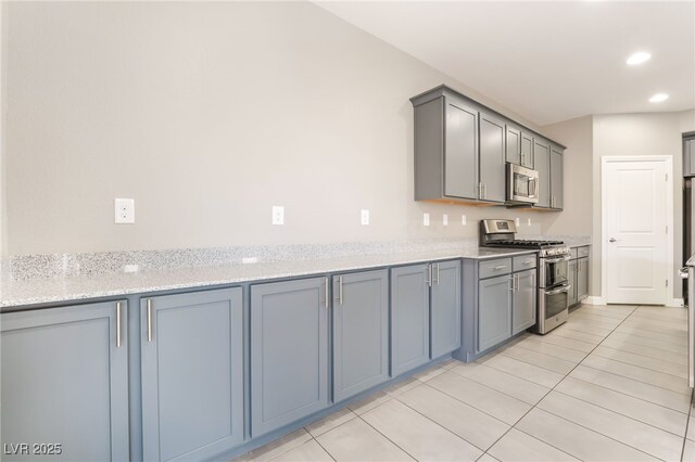 5981 Smith Valley Rd, Las Vegas, NV 89148 - kitchen featuring stainless steel appliances, gray cabinetry, recessed lighting, light tile patterned floors, and light stone countertops