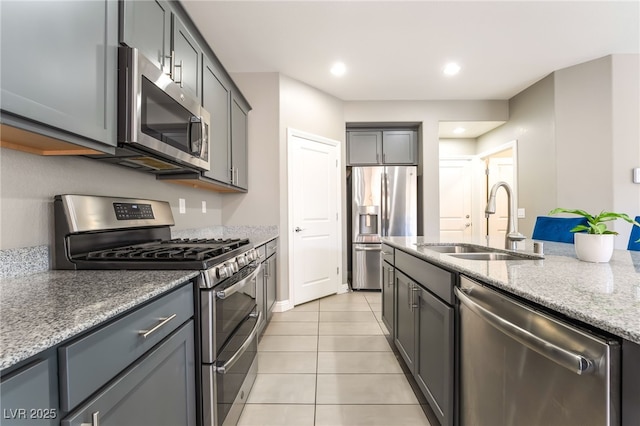 5981 Smith Valley Rd, Las Vegas, NV 89148 - kitchen featuring stainless steel appliances, a sink, light tile patterned flooring, light stone countertops, and gray cabinets