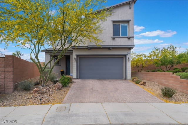 5981 Smith Valley Rd, Las Vegas, NV 89148 - view of front facade featuring fence, an attached garage, decorative driveway, and stucco siding