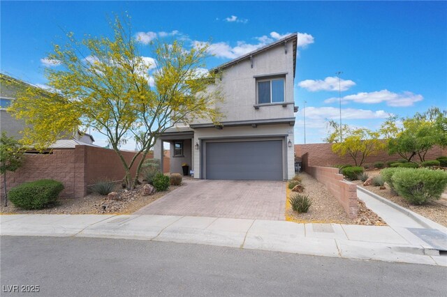 5981 Smith Valley Rd, Las Vegas, NV 89148 - view of front of home featuring an attached garage, decorative driveway, fence, and stucco siding