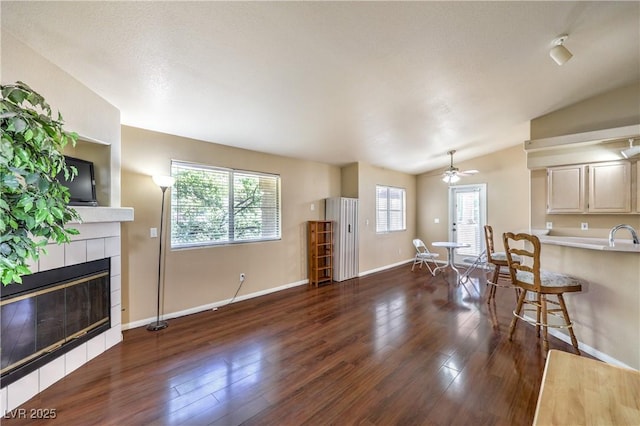 1557 Lake Placid Ter Unit 1557, Henderson, NV 89014 - living room with a fireplace, a ceiling fan, wood finished floors, baseboards, and vaulted ceiling