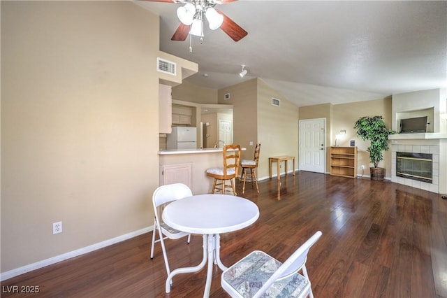 1557 Lake Placid Ter Unit 1557, Henderson, NV 89014 - dining room featuring ceiling fan, vaulted ceiling, baseboards, wood finished floors, and a fireplace