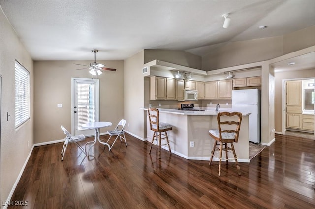 1557 Lake Placid Ter Unit 1557, Henderson, NV 89014 - kitchen featuring white appliances, dark wood-style floors, light countertops, lofted ceiling, and a kitchen breakfast bar