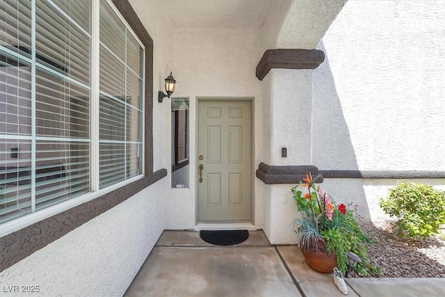 view of exterior entry with stucco siding