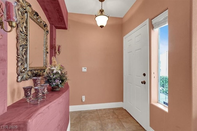 foyer entrance featuring healthy amount of natural light, light tile patterned floors, and baseboards