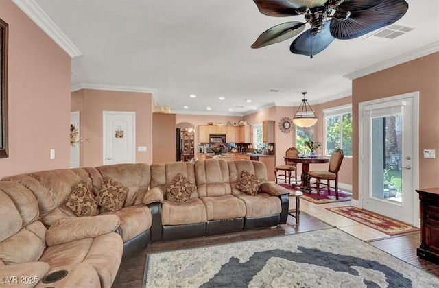 living area with ceiling fan, crown molding, light wood-style floors, and recessed lighting