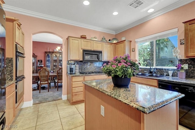 kitchen with black appliances, arched walkways, light brown cabinetry, a sink, and stone counters