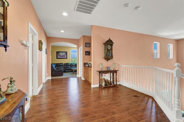 hall with arched walkways, wood-type flooring, recessed lighting, and baseboards