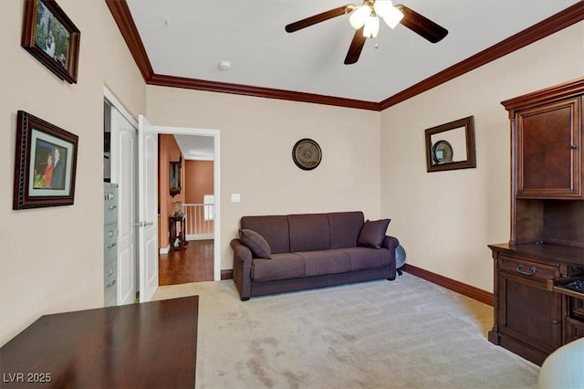 carpeted living room featuring a ceiling fan, ornamental molding, and baseboards
