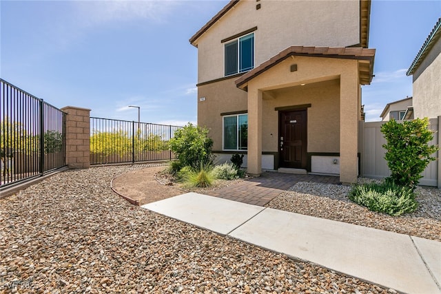 view of front of house with stucco siding and a fenced backyard
