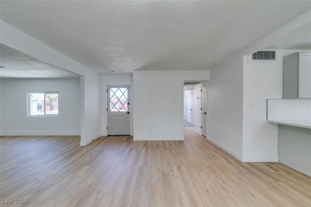212 View Dr, Las Vegas, NV 89107 - unfurnished living room with a textured ceiling, light wood finished floors, and baseboards