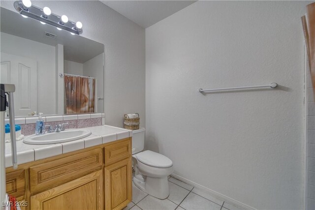 3581 Margarita Ave, Pahrump, NV 89048 - full bathroom with tile patterned flooring, toilet, vanity, a shower with curtain, and baseboards