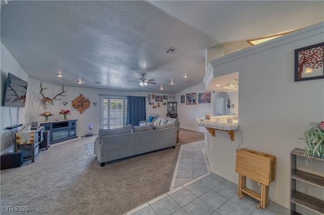 3581 Margarita Ave, Pahrump, NV 89048 - living area with vaulted ceiling, light carpet, ceiling fan, arched walkways, and light tile patterned floors